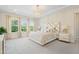 Luxurious main bedroom with a decorative tray ceiling, plush carpet, and bright, natural light at 713 Ramsours Mill Dr, Holly Springs, NC 27540