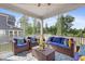 Screened porch area furnished with wicker furniture, vibrant cushions, and peaceful view of the landscaped backyard at 713 Ramsours Mill Dr, Holly Springs, NC 27540