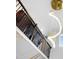 Elegant staircase featuring a modern chandelier, dark wood railing, and decorative gold trim at 713 Ramsours Mill Dr, Holly Springs, NC 27540