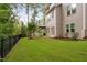 Spacious backyard featuring a lush green lawn, black fence and deck with steps at 728 Peninsula Forest Pl, Cary, NC 27519