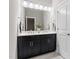 Well-lit bathroom with a double sink vanity featuring dark cabinets and ample counter space at 728 Peninsula Forest Pl, Cary, NC 27519
