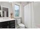 Bathroom featuring a vanity with dark cabinets, a subway tiled shower, and an accent window at 728 Peninsula Forest Pl, Cary, NC 27519