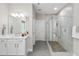 Bright bathroom featuring a glass enclosed shower with pebble floor and a sink with white cabinets and countertop at 728 Peninsula Forest Pl, Cary, NC 27519