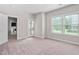 Cozy bedroom featuring soft carpeting, a bright window, and a private door leading to a charming balcony at 728 Peninsula Forest Pl, Cary, NC 27519
