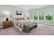 Serene bedroom with large windows, plush carpet, and inviting decor for ultimate relaxation at 728 Peninsula Forest Pl, Cary, NC 27519