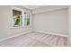 This bedroom has neutral walls, carpet floors, and a large window with a view of the staircase at 728 Peninsula Forest Pl, Cary, NC 27519