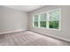 This bedroom has neutral walls, carpet floors, and a large window with green views at 728 Peninsula Forest Pl, Cary, NC 27519