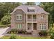 An exterior view highlighting the home's stone and siding, complemented by manicured landscaping at 728 Peninsula Forest Pl, Cary, NC 27519