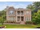 Stunning stone-clad two-story home featuring a second-story balcony and a beautifully landscaped front yard at 728 Peninsula Forest Pl, Cary, NC 27519