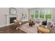 Bright living room featuring a fireplace, large windows, and modern neutral decor at 728 Peninsula Forest Pl, Cary, NC 27519