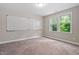 A neutral home office space featuring carpet floors, a white board, and a window at 728 Peninsula Forest Pl, Cary, NC 27519