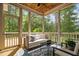 Screened-in porch with cozy seating and a view of wooded backyard at 728 Peninsula Forest Pl, Cary, NC 27519