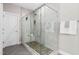 Beautiful glass shower with a pebble floor, bench seating, and multiple shower heads at 728 Peninsula Forest Pl, Cary, NC 27519
