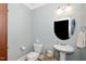 Elegant powder room with a pedestal sink, round mirror, and neutral paint, offering a classic look at 734 Portstewart Dr, Cary, NC 27519