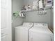 Functional laundry room with a washer, dryer, and shelving for storage, maximizing space efficiency at 734 Portstewart Dr, Cary, NC 27519