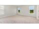 Spacious bedroom with three windows offering natural light and neutral carpet flooring at 74 W Emily Gardens Dr, Selma, NC 27576