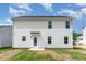Back of new construction home featuring white vinyl siding, black roof, and a grassy yard at 74 W Emily Gardens Dr, Selma, NC 27576