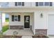 Inviting front entrance featuring a stylish black door, stone accents, and a cozy covered porch at 74 W Emily Gardens Dr, Selma, NC 27576