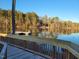 Scenic view of the lake from the wooden dock, with calm waters and lush trees reflecting the sunlight at 75 Slippery Elm Rd, Youngsville, NC 27596