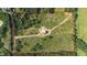 Expansive acreage with a modern home, gravel driveway, and surrounded by lush greenery; property line is highlighted in red at 7620 Sam Hall Rd, Oxford, NC 27565