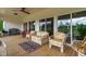 Large covered back porch with multiple seating options, outdoor ceiling fan, and natural light at 7620 Sam Hall Rd, Oxford, NC 27565