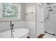 Bathroom with a soaking tub, white marble walls, a glass shower, and a towel bar at 7620 Sam Hall Rd, Oxford, NC 27565