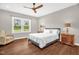 Bright bedroom with a ceiling fan, a comfortable bed, and wood flooring at 7620 Sam Hall Rd, Oxford, NC 27565