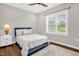 Comfortable bedroom with wooden floors, a ceiling fan, and natural light from the windows at 7620 Sam Hall Rd, Oxford, NC 27565