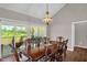 Formal dining room features a wooden table set, decorative chandelier and sliding glass door to the outside at 7620 Sam Hall Rd, Oxford, NC 27565