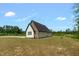 A modern home exterior displays light siding with black stone accent on the gable end in a spacious yard at 7620 Sam Hall Rd, Oxford, NC 27565