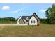 Stunning two-story home featuring white siding, stone accents, black trim and a well-manicured front yard at 7620 Sam Hall Rd, Oxford, NC 27565