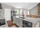 Kitchen island with granite countertops, gray cabinets, stainless steel appliances and brown flooring at 7620 Sam Hall Rd, Oxford, NC 27565