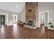 Elegant living room featuring wood-look tile floors, a grand stone fireplace, and ample natural light at 7620 Sam Hall Rd, Oxford, NC 27565