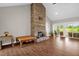 An expansive living room features a striking stone fireplace, wood-look tile floors, and sliding glass doors at 7620 Sam Hall Rd, Oxford, NC 27565