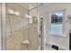 Modern bathroom featuring a glass shower with a built-in seat and a bright window at 7917 Featherstone Dr, Raleigh, NC 27615