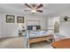 Cozy bedroom with a wooden bed frame, ceiling fan, and two framed paintings on the wall at 7917 Featherstone Dr, Raleigh, NC 27615