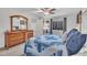 Bright bedroom with a large window, wooden dresser, ceiling fan and a comfortable-looking bed at 7917 Featherstone Dr, Raleigh, NC 27615