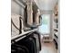 Organized closet with hanging clothes, shelving, and a window providing natural light at 7917 Featherstone Dr, Raleigh, NC 27615