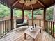 Cozy gazebo interior with wicker furniture, wooden ceiling fan, and a tranquil view of the surrounding greenery at 7917 Featherstone Dr, Raleigh, NC 27615