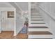 Bright hallway leads to a dining room; staircase with wooden treads and white risers at 7917 Featherstone Dr, Raleigh, NC 27615