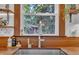 Close up of a stainless steel sink under a window with butcher block countertops and unique decorative open shelving at 7917 Featherstone Dr, Raleigh, NC 27615
