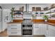 Well-appointed kitchen with modern appliances, wooden countertops, and stylish open shelving at 7917 Featherstone Dr, Raleigh, NC 27615