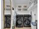 Well-organized laundry room features a modern washer and dryer, ample shelving, and stylish storage baskets at 7917 Featherstone Dr, Raleigh, NC 27615