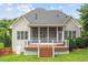 Back exterior view showcasing a screened porch and small deck with stairs to the yard at 10012 San Remo Pl, Wake Forest, NC 27587