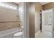 Bright bathroom with tiled shower-tub combination and white toilet in updated neutral tones at 10012 San Remo Pl, Wake Forest, NC 27587