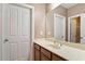 Neutral-toned bathroom featuring a single vanity and large mirror over a tile floor at 10012 San Remo Pl, Wake Forest, NC 27587