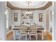 Elegant dining room with a modern chandelier, decor shelving, and seating for six around a wooden table at 10012 San Remo Pl, Wake Forest, NC 27587