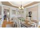 Cozy dining room with a rustic wooden table set for dinner, and a transitional view into an open living area at 10012 San Remo Pl, Wake Forest, NC 27587