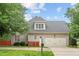 Home's front exterior with two car garage, well-manicured lawn, and mature trees at 10012 San Remo Pl, Wake Forest, NC 27587