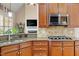 Close-up of kitchen featuring wood cabinets, granite countertops, and stainless steel appliances at 10012 San Remo Pl, Wake Forest, NC 27587